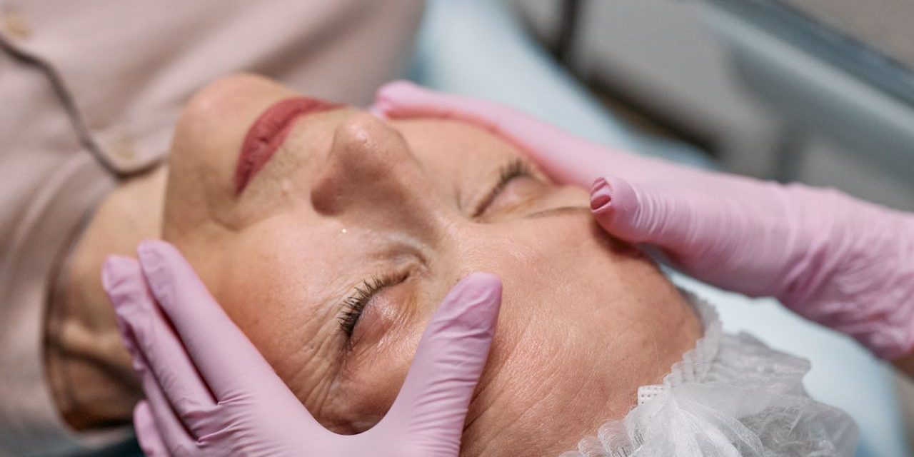 A serene spa therapy session with a senior woman enjoying a facial massage for rejuvenation.